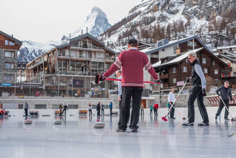 curling ice rink in the village of Zermatt, Switzerland with lodges and the Matterhorn in the background