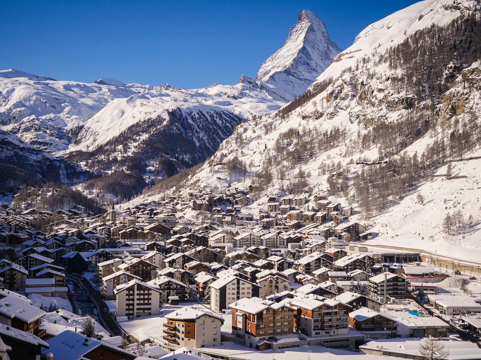 white and brown houses on snow covered mountain during daytime in Zermatt Switzerland